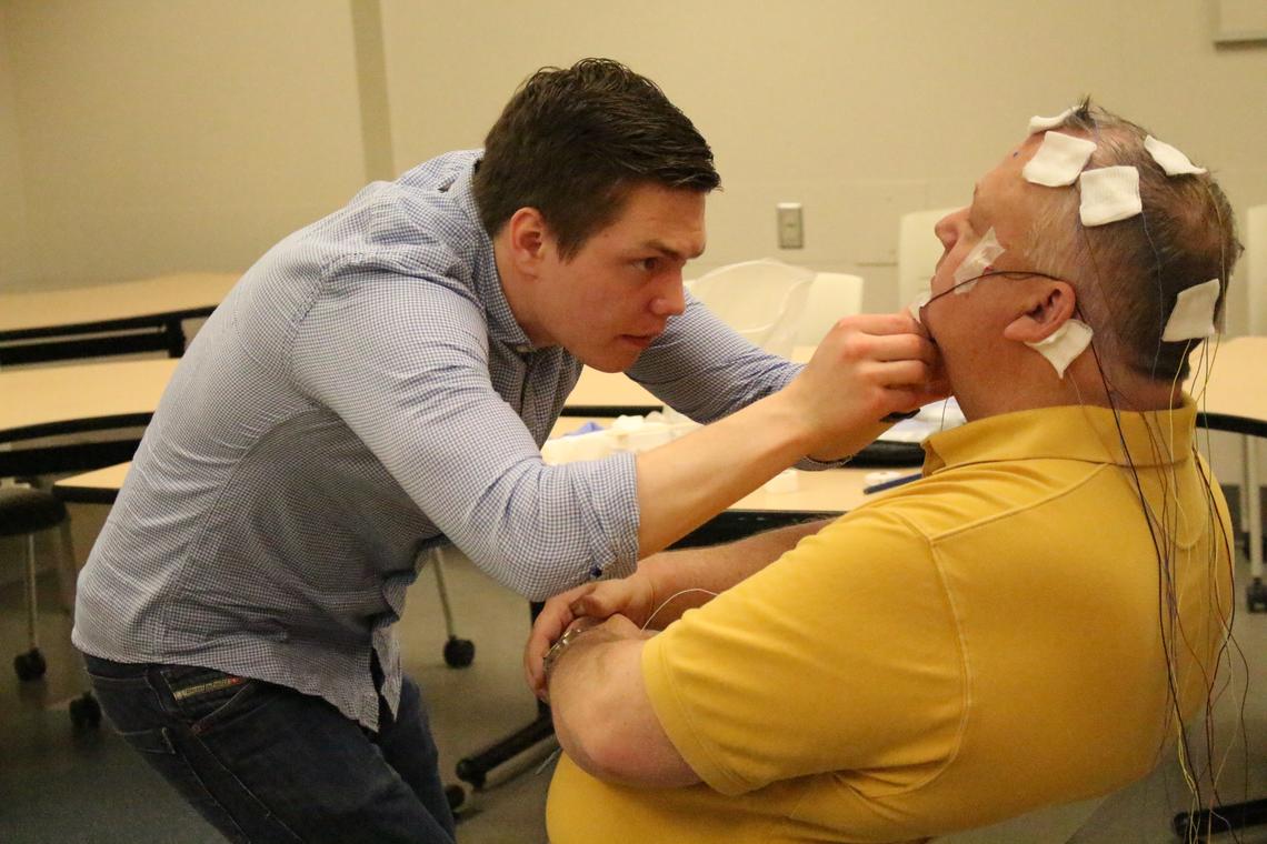 Scott MacKay performs an electroencephalography (EEG) recording on his father at the UCalgary Foothills campus.