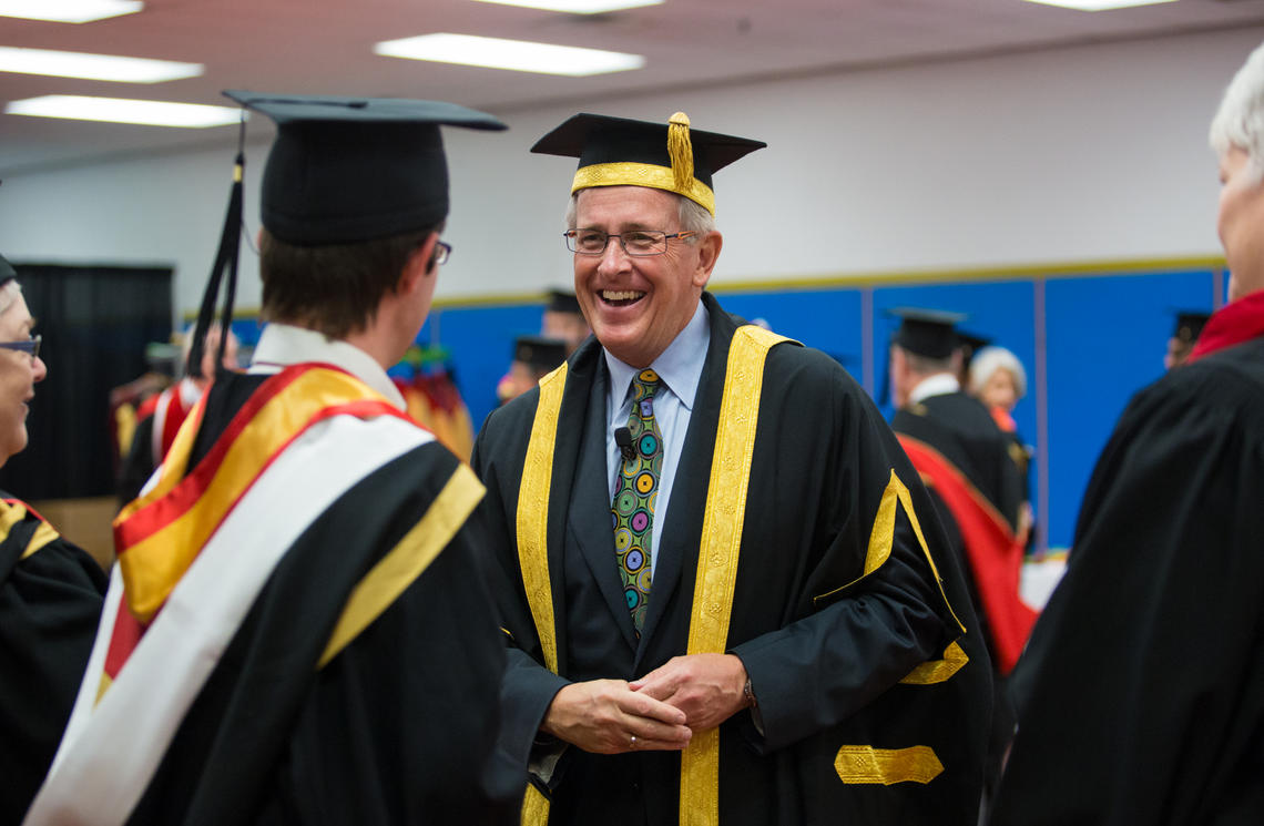 Chancellor Jim Dinning visits with a student during convocation ceremonies at the University of Calgary in June 2014. 