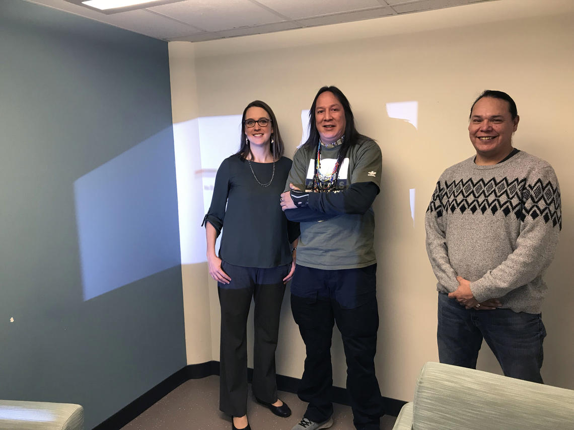 Nursing instructor Heather Bensler stands with artist Kalum Teke Dan and his assistant Jamie Carlson before the mural was painted.