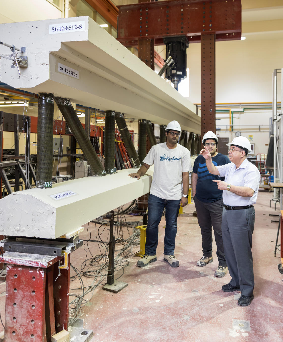 Professor Mamdouh El-Badry, right, discusses a test model of his special span with students.