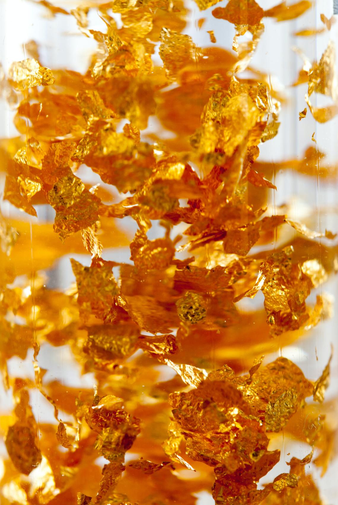 Gold flakes suspended in clear liquid