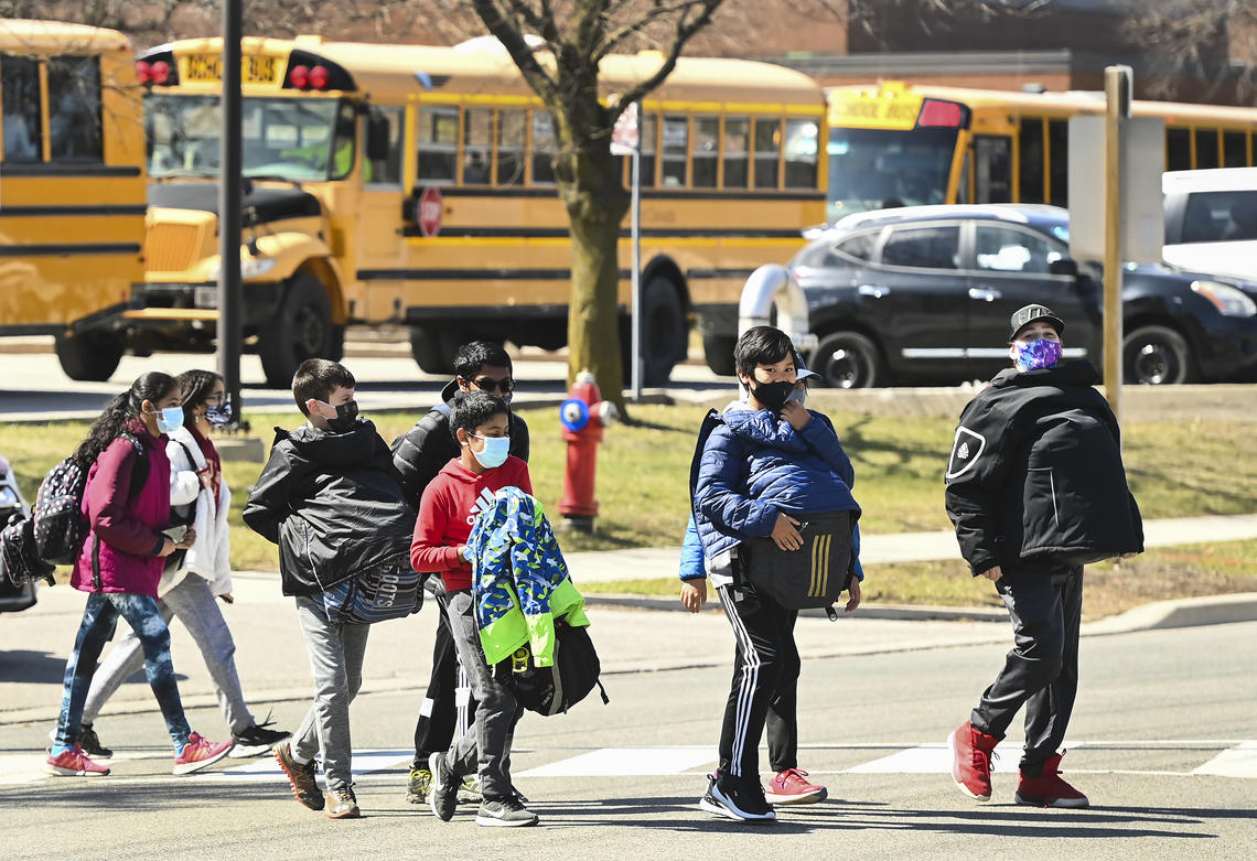 Students cross the street at Tomken Road Middle School in Mississauga, Ont., on April 1, 2021. 