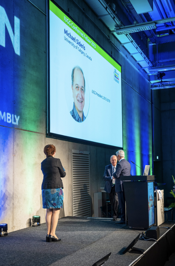 Dr. Sideris receiving the Fellowship from the incoming IUGG President, Prof. Chris Rizos