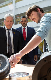Ben Hewitt (left) and Seyedarmin Seyed-Agha-Zadeh (right), Schulich School of Engineering students and members of Student Organization for Aerospace Research (SOAR), show components of a rocket to Minister Dan Vandal and MP George Chahal at the funding announcement on June 26, 2023